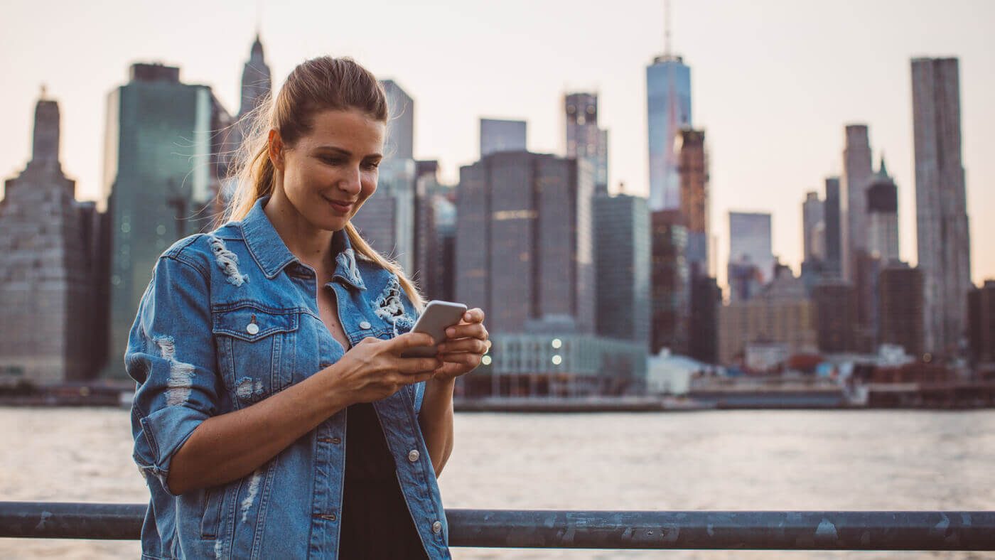 Personne devant la skyline de NYC utilisant son forfait téléphone USA