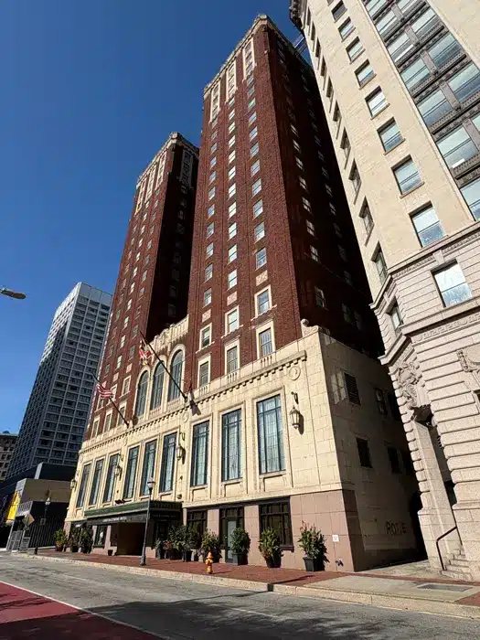 Un hôtel en briques de plusieurs étages, avec un soubassement en pierre de couleur crème, un choix idéal pour où dormir à Baltimore, vu depuis la rue.