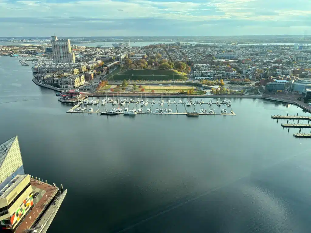 Vue aérienne d'un port de plaisance de Baltimore regorgeant de voiliers, avec un parc et un paysage urbain en arrière-plan, idéale pour ceux qui visitent Baltimore en trois jours.