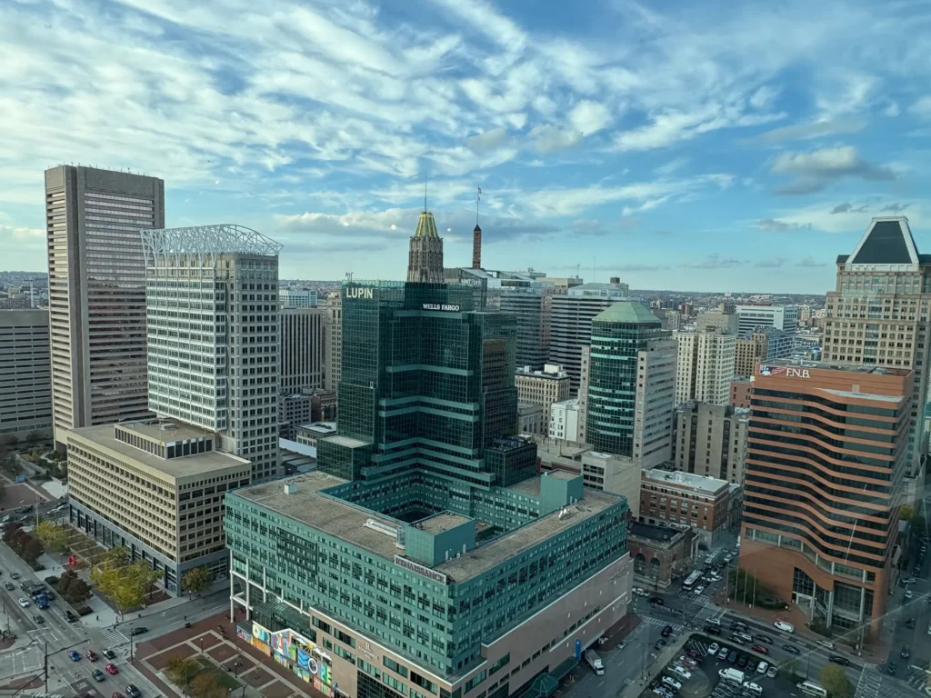 Vue plongeante sur la silhouette de la ville de Baltimore sous un ciel bleu parsemé de nuages, idéale pour ceux qui visitent Baltimore.